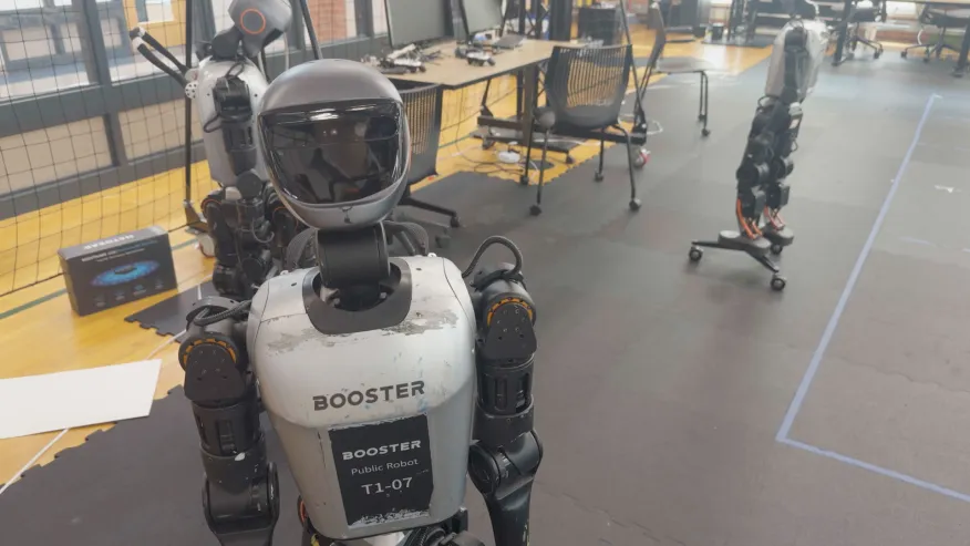 A Booster humanoid robot in a robotics lab, shown in KXAN's coverage.