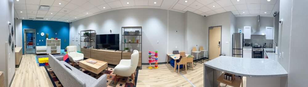 Panoramic view of Chen Yu's HOME Lab at UT Austin, with living-room seating, children's play areas, a dining table, and a kitchen.